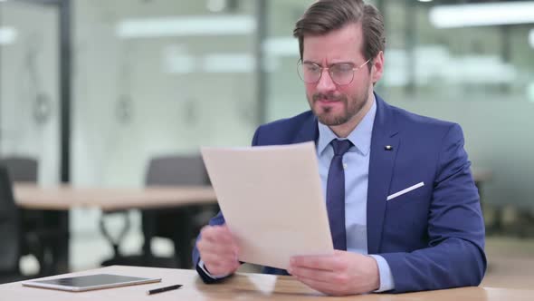Disappointed Young Businessman Trying to Write on Paper alt
