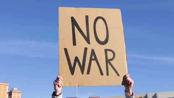 People on the Street PROTEST Against WAR  Woman Holding Banner alt