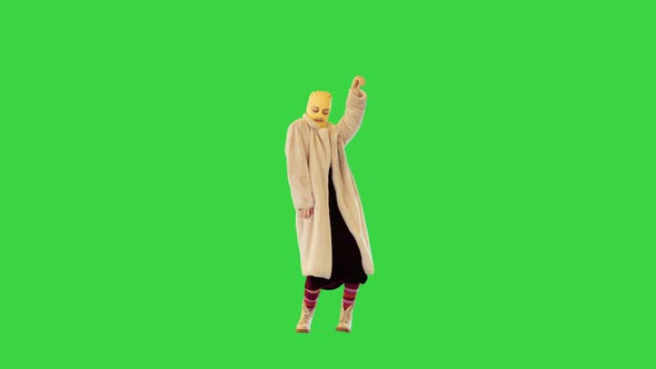Young Daring Girl in Coat and Balaclava Dancing on a Green Screen Chroma Key alt