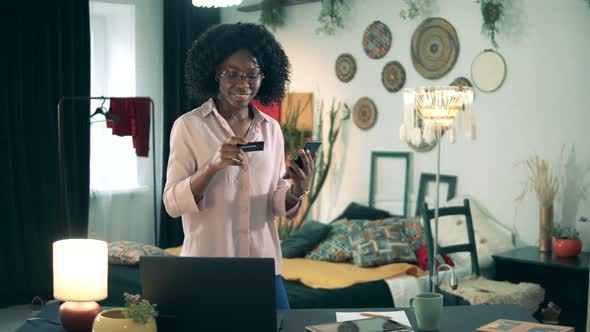 Smiling African-american Woman Is Shopping Online in Quarantine. Remote Shopping, Online Purchase alt