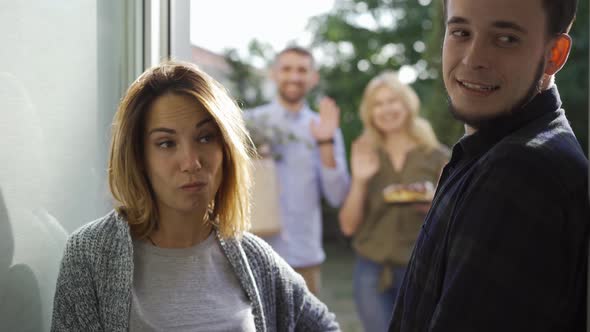 Young European Couple Waiting for Their Neighbors To Leave alt