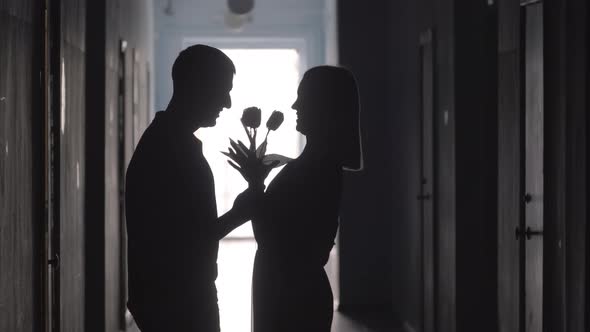 Silhouette of Man with Flowers Meeting Girlfriend in Hallway