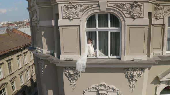 Bride in Boudoir Dress Sitting on Window Sill Wedding Morning Preparations Woman in Night Gown Veil alt