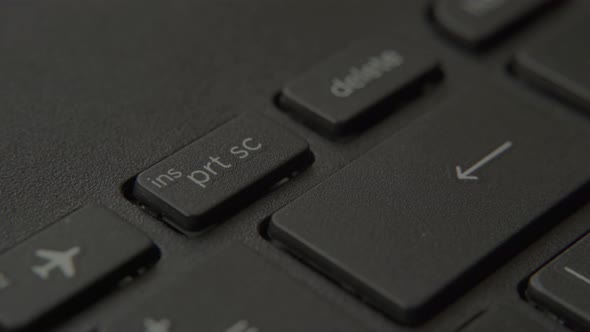 The Finger Presses the Print Screen Button on the Keyboard alt