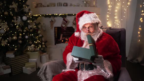 Funny Santa Claus Open Box With Christmas Presents. Choosing New Year Gifts. Santa Delivery Presents