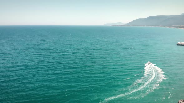 Luxury speedboat cruising in turquoise lagoon.  alt
