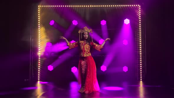 Young Girl Dancing in a Dark Studio with Smoke and Purple Neon Lights, Attractive Brunette in Red alt