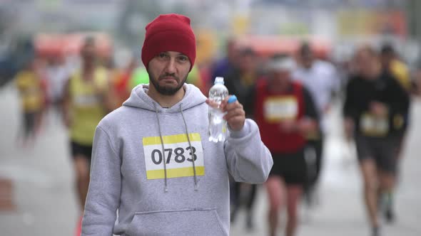 Portrait of Drinking Water and Looking at Camera Sportsman on Marathon Event