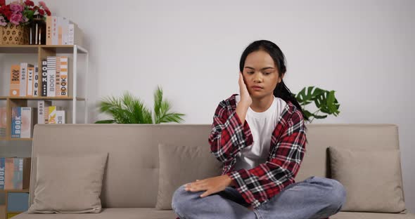 Girl headache while sitting on couch alt