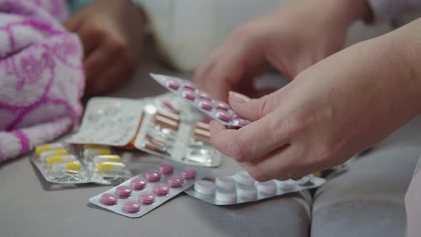 Female Hands Choosing Medicine for Treatment alt