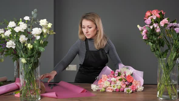 Florist Woman Makes Elegant Wedding Bouquet with Roses alt