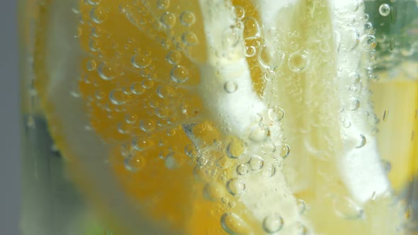 A Refreshing Soft Drink. Mojito Is Poured Into a Glass Close-up. Lemon Mint and Sparkling Water with