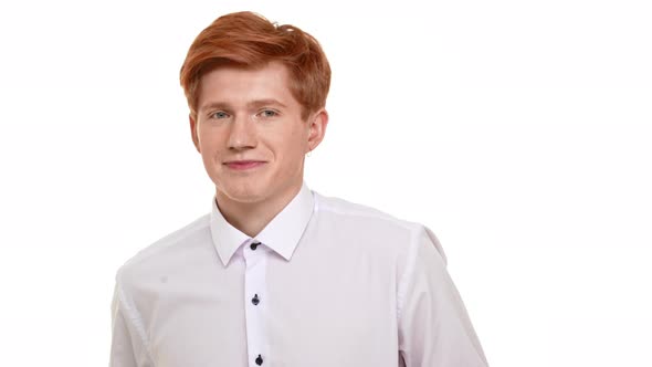 Shy Handsome Caucasian Foxy Young Man Standing on White Background Looking at Camera with alt