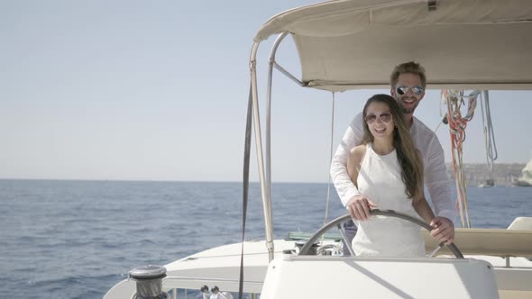 Romantic Owner Couple Steering Their Catamaran Together