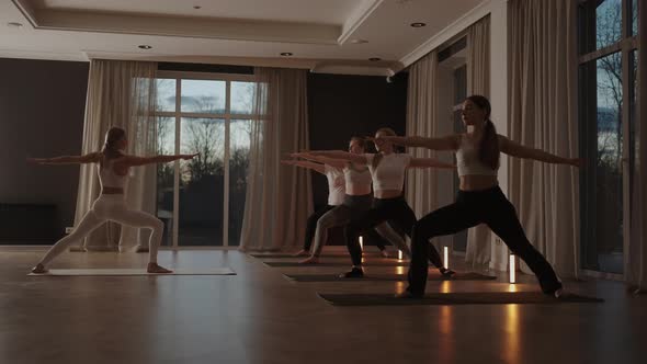 A Group of Women is Engaged in Stretching and Balance with an Instructor in a Beautiful Hall with alt