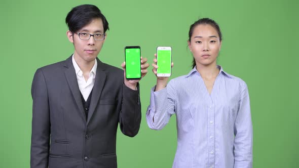 Young Asian Business Couple Showing Phone Together