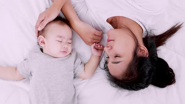 Happy family, Young mother care for her baby girl who is sleeping on the bed. slow motion shot.