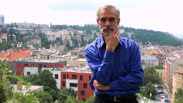 Old Senior Man Thinks About Something - City (Buildings) in Background alt