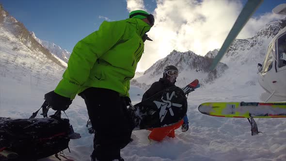 A helicopter landing to pick up skiiers for skiing and snowboarding in the mountains. alt