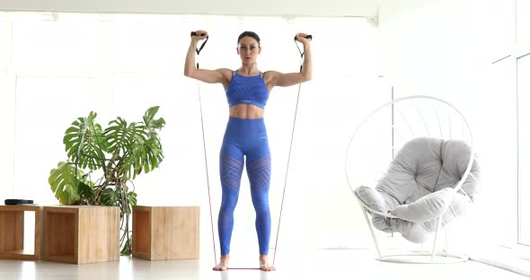 Woman during her fitness workout at home with rubber band.