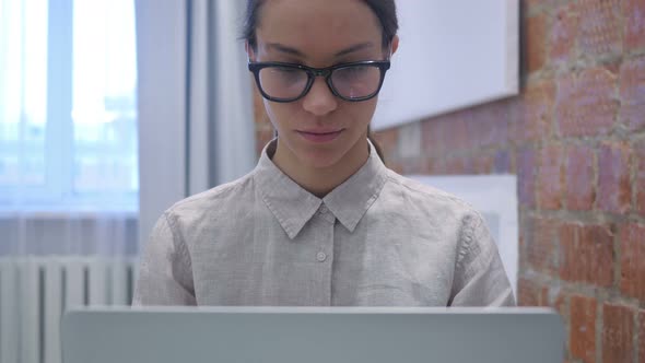 Hispanic Woman Working on Laptop in Office, Close Up alt