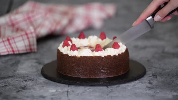 Cutting Homemade Raspberry Chocolate Cheesecake. alt