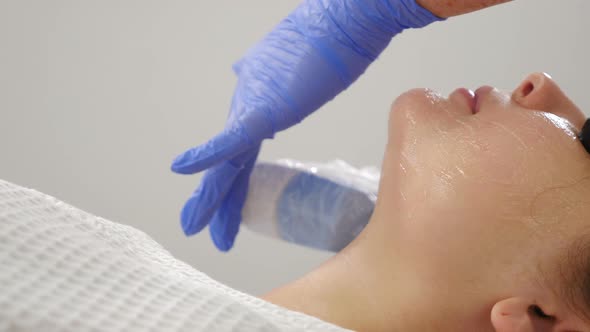 Nonsurgical Facelift in Beauty Salon. Machine Cosmetology. Facelift Device Makes Flashes. Faceskin alt