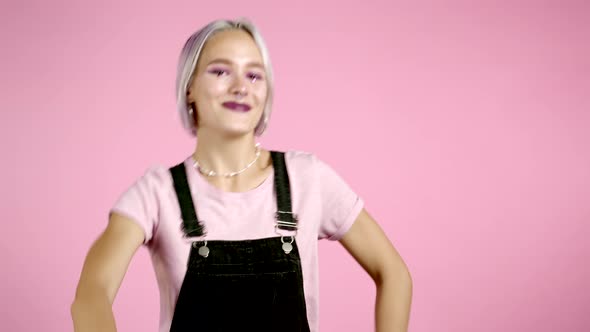 Beautiful Hipster Woman Dancing with Colorful Hairstyle Energetically and Actively on Pink Studio alt