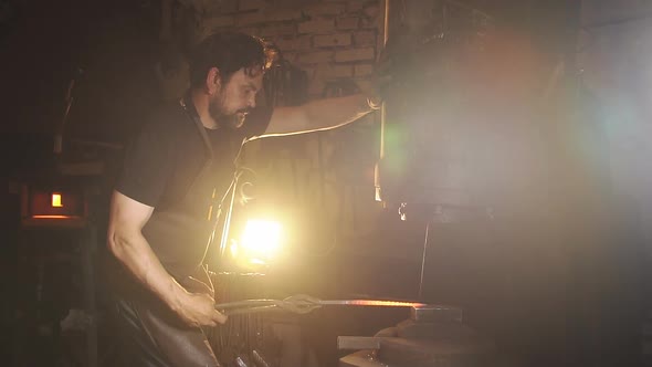 Blacksmith Handles the Pressure of the Workpiece From the Melted Metal. Slow Motion