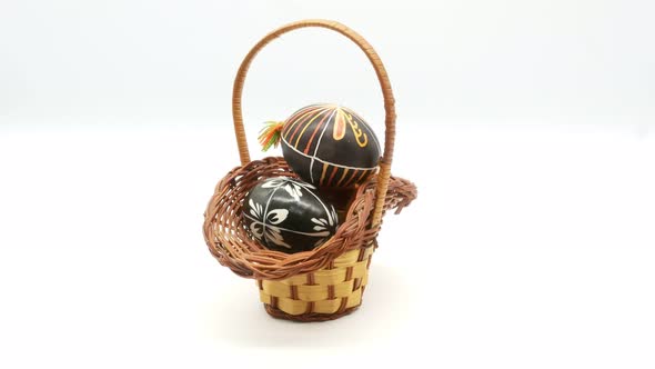 Decorative Basket with Painted Easter Eggs on White Background