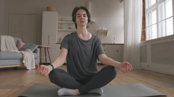 Young Woman Meditates at Home