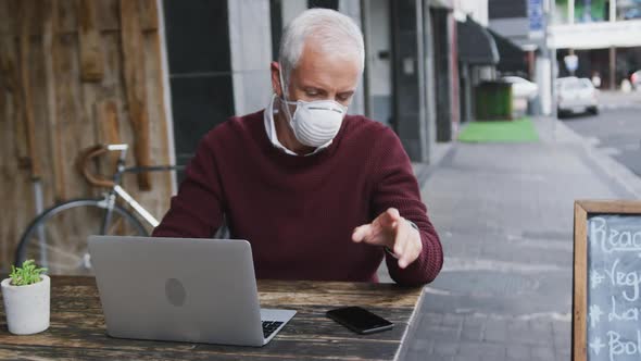 Caucasian man out and about in a coffee wearing a face mask against coronavirus alt