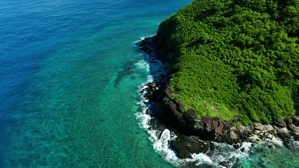 Tropical nature of a Fijian Island surrounded by perfect blue water, aerial shot alt