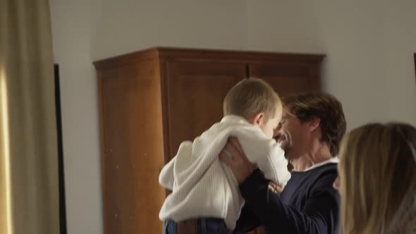 Happy parents having fun with cute little children at home alt