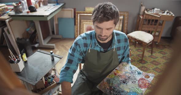 Male Painting on Molbert in Studio