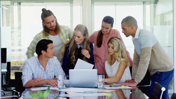 Colleagues interacting with each other at table 4k alt
