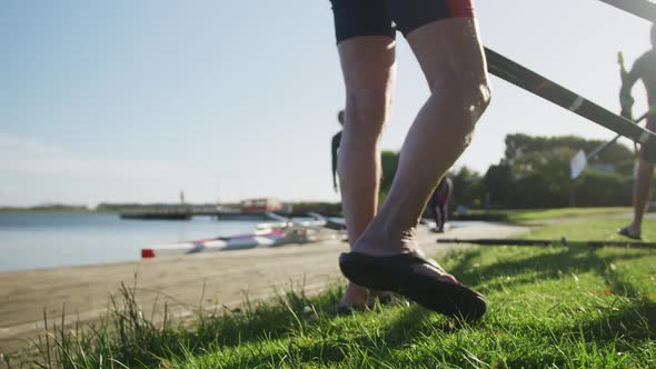 Four senior caucasian men and women preparing rowing boat in a river alt