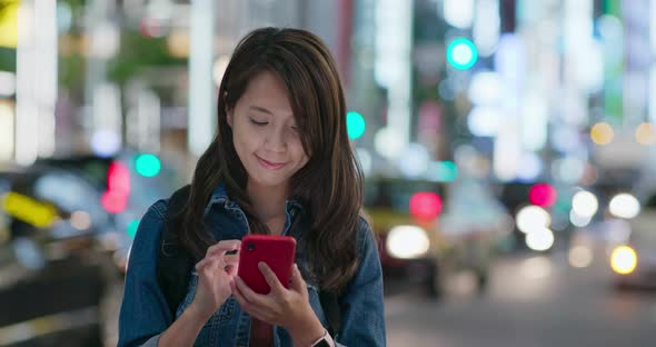 Woman use of mobile phone in Tokyo city at night alt