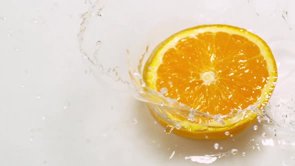 Orange, citrus sinensis, Slice Falling on Water and splashing, against White Background, Slow Motion