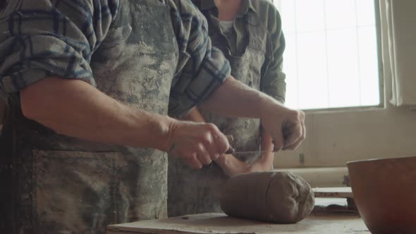 Senior Artisan Teaching Young Woman Pottery alt