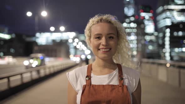 Portrait of pretty young woman standing on bridge in London, UK alt