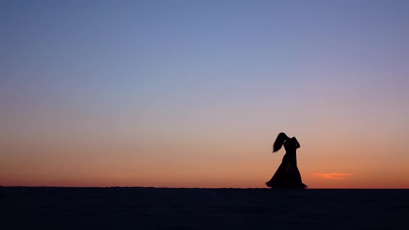 Professional Cute Dancer on the Beach Dances Belly Dancing. Silhouette alt
