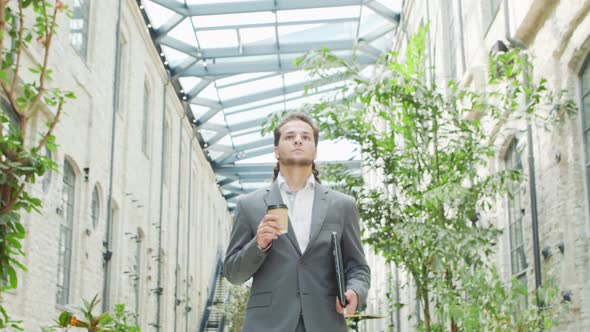 A young successful businessman is walking down the street. Man in a casual wear. alt