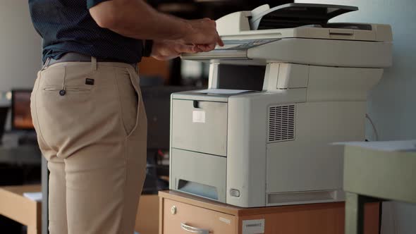Man Finger Press Buttons On Multifunctional Copier. Man Using Printer Or Scanner In Office.Workplace alt