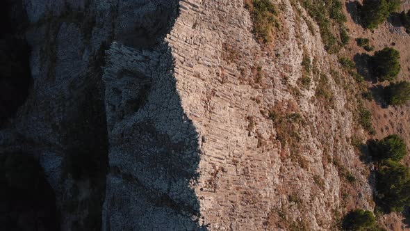 Dramatic flight directly above and along Ana Ferreira rocky stone steep jagged and pointy peak ridge alt