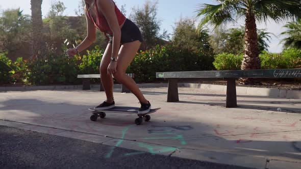 Beautiful Young Girl Rides on Road Near Beach and Palm Trees on Longboard in Slow Motion alt