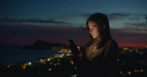 Young Woman Look at Phone in Sunset Light