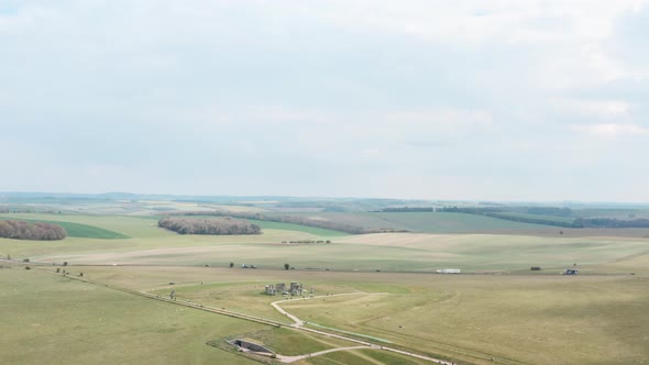 Wide rising circling drone shot of Stonehenge near A303 highway UK alt