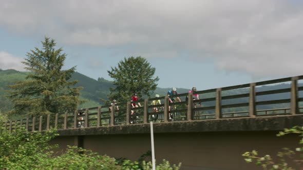 Group of cyclists on road ride over bridge.  Fully released for commercial use.