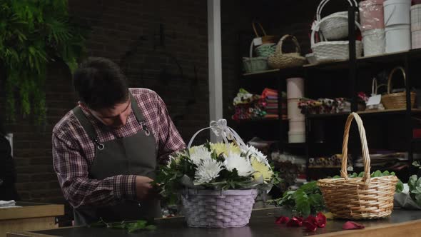 Florist Checking a Basket of White Chrysanthemums alt